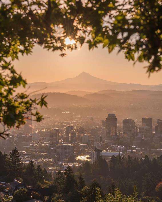 Horizonte de edificios altos y montañas durante la salida del sol en Portland, Oregón. Foto de @50shadesofpnw de usuario de Instagram