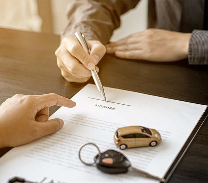 Entender los detalles de tu financiamiento es crucial. Una persona revisando documentos de financiación de un auto.