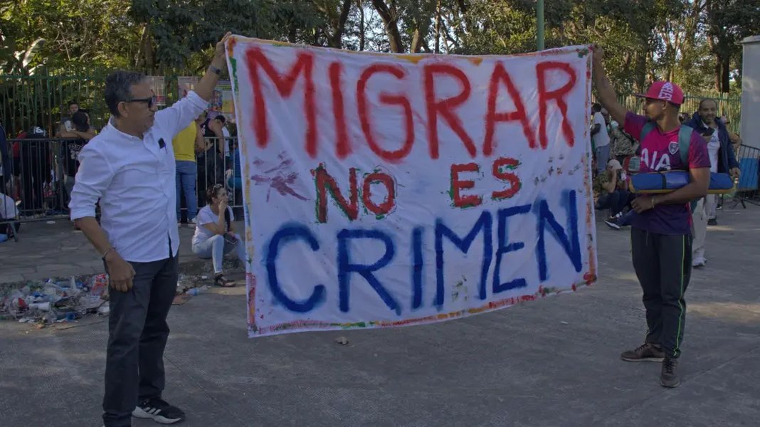 Grupo de migrantes sosteniendo un cartel en Tapachula.