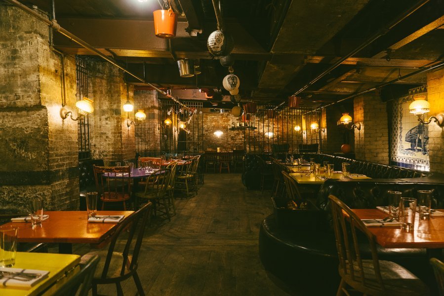 El ambiente distintivo de la brasserie subterránea de La Esquina. Interior de la brasserie subterránea de La Esquina en Nolita, con luces tenues y un ambiente vibrante.